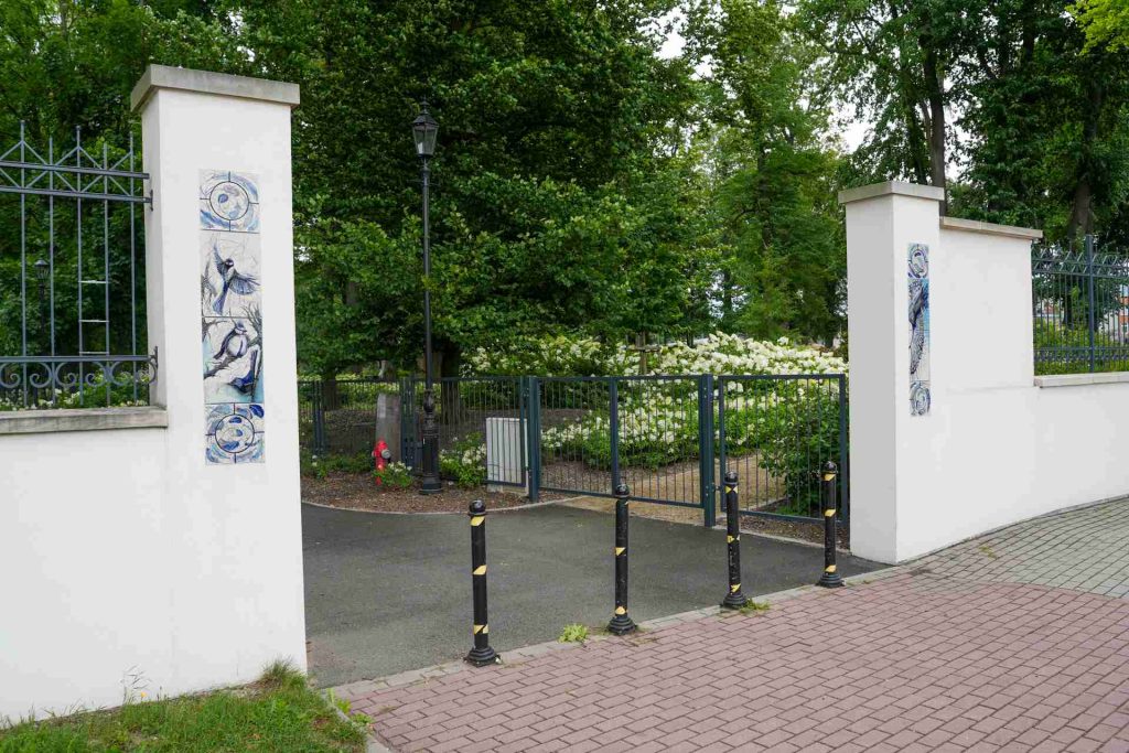 Wejście do parku przy pałacu w Bolesławcu z ozdobnymi ceramicznymi dekoracjami